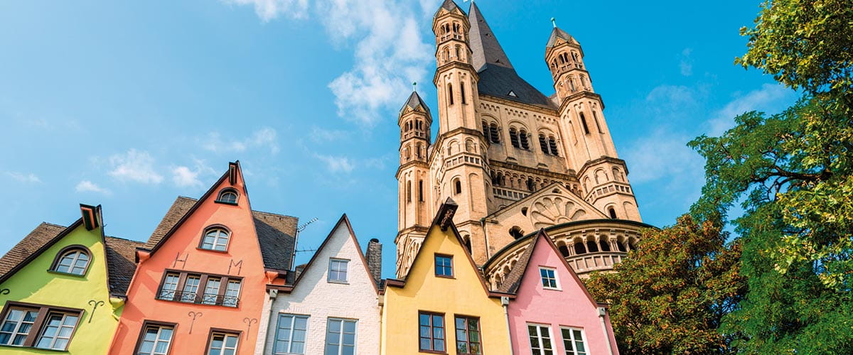 A view up towards St Martin Church in Cologne, with colourful houses in front, Germany